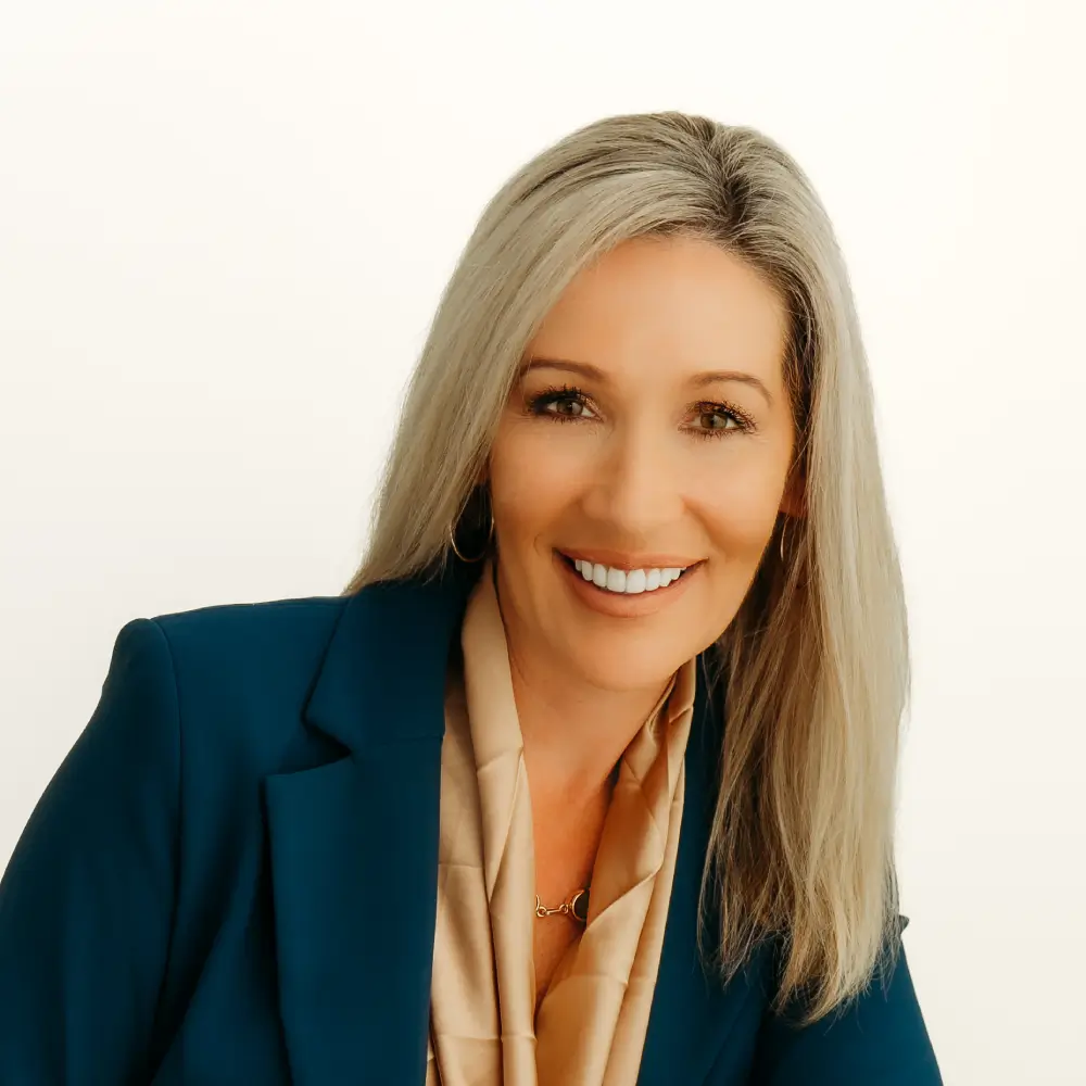 Smiling woman with long blonde hair in a blue blazer.
